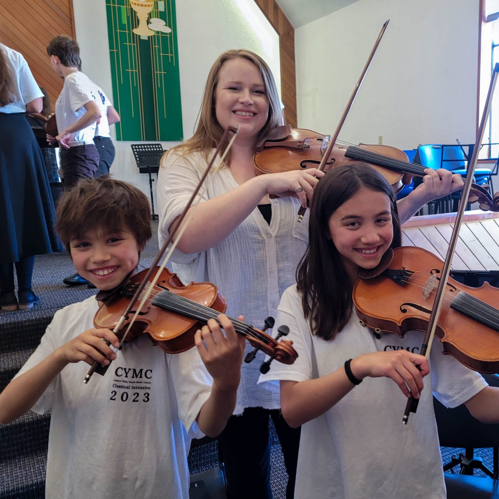 teacher with students playing violins